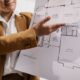 Real estate agent explaining a single storey house floor plan with vaulted family room and dining room