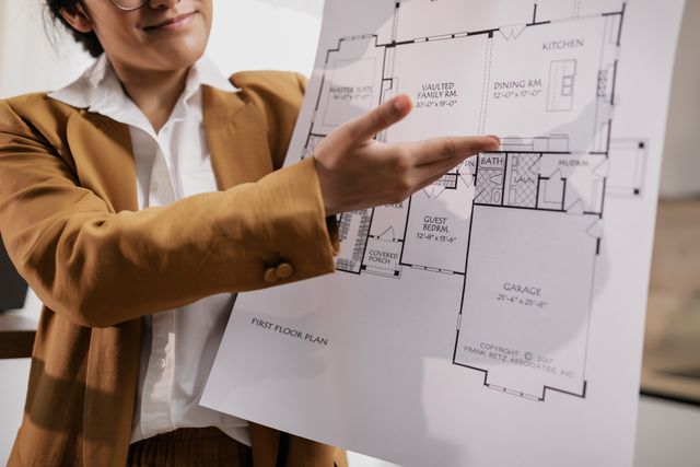 Real estate agent explaining a single storey house floor plan with vaulted family room and dining room