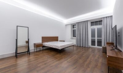 LED bedroom furniture setup with ceiling cove lighting, wooden bed frame, and nightstands in a modern bedroom