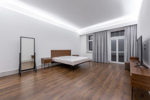 LED bedroom furniture setup with ceiling cove lighting, wooden bed frame, and nightstands in a modern bedroom