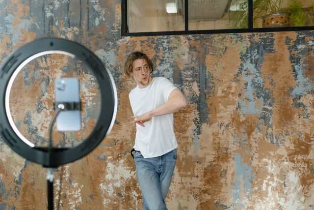 Social media influencer recording dynamic trending video content for TikTok and Instagram Reels using a ring light setup.